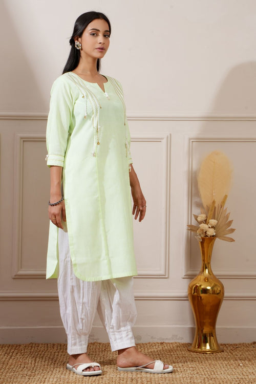 Lime green cotton straight kurta with white afghani pants, angled side view